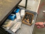 un tiroir rempli d'outils posé sur une table