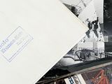 a pile of old photos on a table next to a pile of books