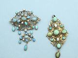 two antique brooches with turquoise and white stones on them