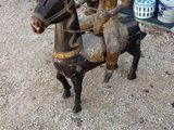 une statue représentant un homme à cheval, à côté d'autres statues