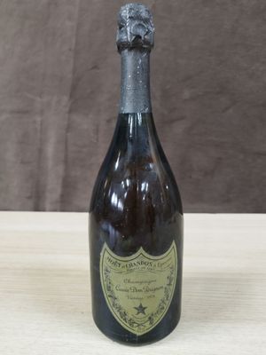 une vieille bouteille de vin posée sur une table en bois