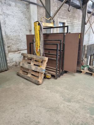 un tas de palettes dans un entrepôt dont la porte est ouverte
