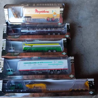six trains miniatures exposés dans une vitrine posée au sol