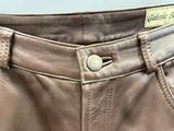 the back of a pair of brown leather pants with a label on it