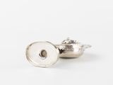 a close up of a pair of silver buttons on a white surface