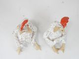 two figurines of chickens on a white surface