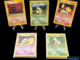 Quatre cartes Pokémon différentes sont représentées sur un fond noir.