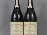 two bottles of wine sit on a table with a gray background