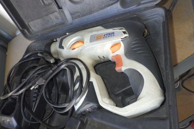 un pistolet à colle sans fil dans un étui muni d'un cordon d'alimentation