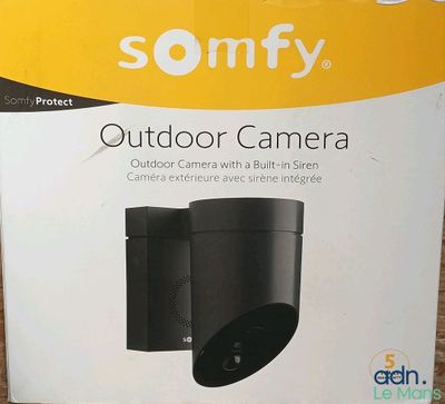 une boîte avec un appareil photo à l'intérieur sur le sol
