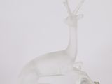 sculpture of a white deer on a clear base on a white surface