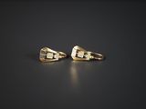 une paire de boucles d'oreilles en or sur une surface noire