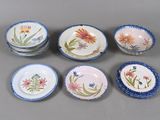 plusieurs assiettes et bols décorés de fleurs, posés sur une table