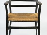 a black wooden chair with a woven seat and armrest
