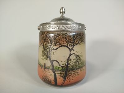 a small jar with a painting on it sitting on a table