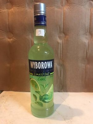 a bottle of vodka with lime and mint on the table