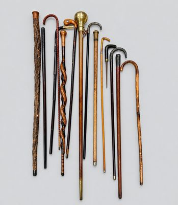 a group of old canes and cane sticks on a white surface