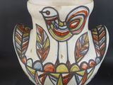 un vase blanc orné d'un oiseau sur fond noir