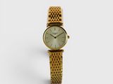 une photo d'une montre-bracelet pour femme posée sur une surface blanche