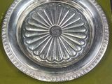 a silver plate with a flower design on it