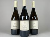 trois bouteilles de vin posées sur une table blanche