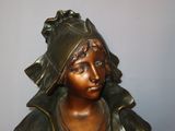 bronze statue of a woman with a hat on her head