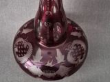 a red glass vase with a spoon next to it