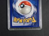 pokemon trading card in plastic case on table with black background