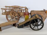 une petite charrette en bois sur laquelle est assis un homme