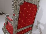 a silver and red chair with a red seat in a white room
