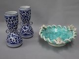 two vases and a bowl sitting on a table