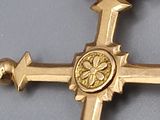 a gold cross with a flower on it on a table