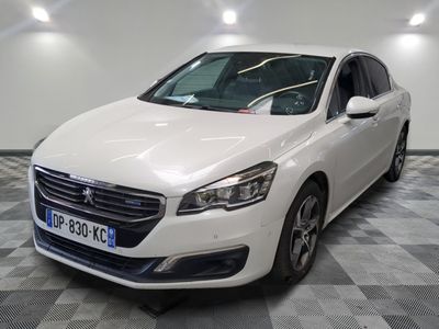 la voiture blanche est garée sur un sol en damier dans le garage