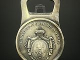 un décapsuleur sur lequel est représenté un blason