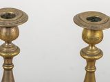 pair of antique brass candlesticks on a white background