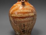 un vase marron orné de motifs sur un fond gris