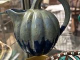 a blue and green vase and a brown and white bowl on display