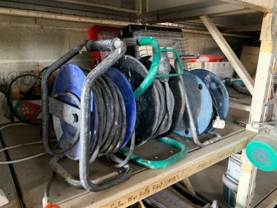 Plusieurs tuyaux sont empilés sur un support dans un garage.