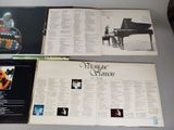 three albums of various music are sitting on a table