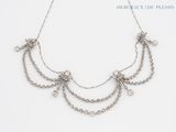 a close up of a necklace on a white surface