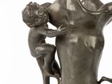 a statue of a child climbing on a vase