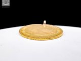 a gold coin sitting on top of a white plate