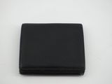 un portefeuille en cuir noir posé sur une surface blanche
