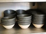 de nombreux bols et casseroles sur l'étagère de la cuisine
