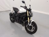 une photo d'une moto blanche et noire garée dans un garage