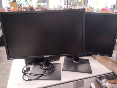 deux écrans d'ordinateur posés sur une table