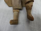 a wooden doll that is sitting on a white sheet