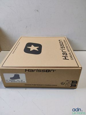 une boîte posée sur une table à côté d'une paire de chaussures
