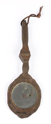 an old metal object hanging on a white wall