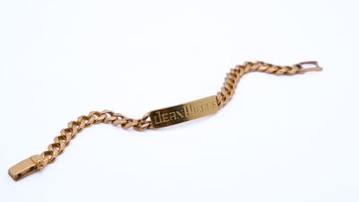 an image of a gold bracelet with a nameplate on it